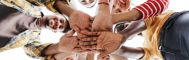 A group of people putting their hands together A group of people putting their hands together